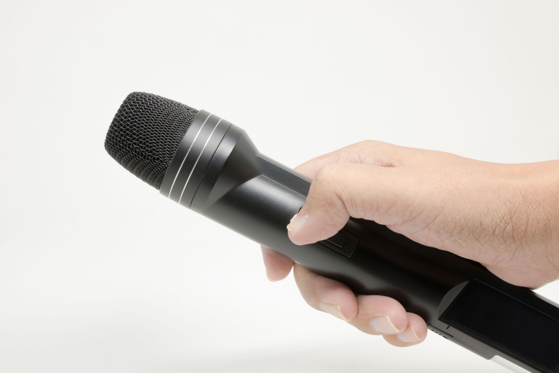 Detailed image of a hand gripping a black microphone, isolated on white.