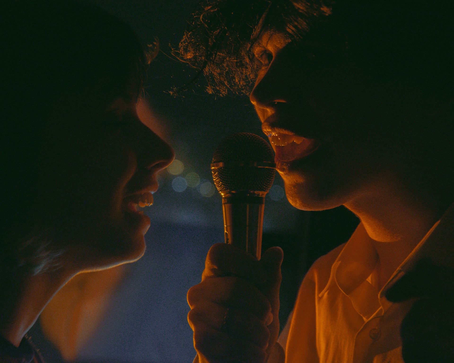 a woman holding a microphone in front of a man
